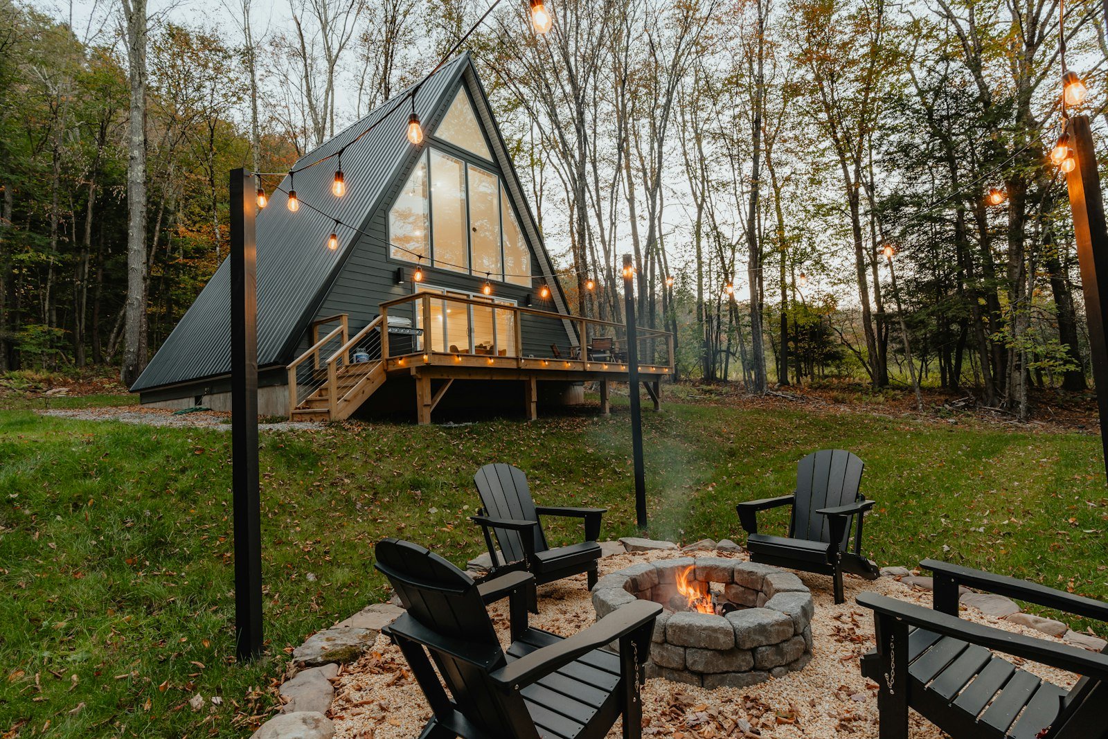 Fire pit and chairs on a lawn in front of a modern house