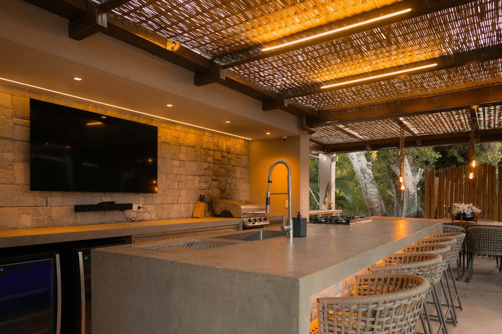 Covered outdoor kitchen with a bar counter and seating