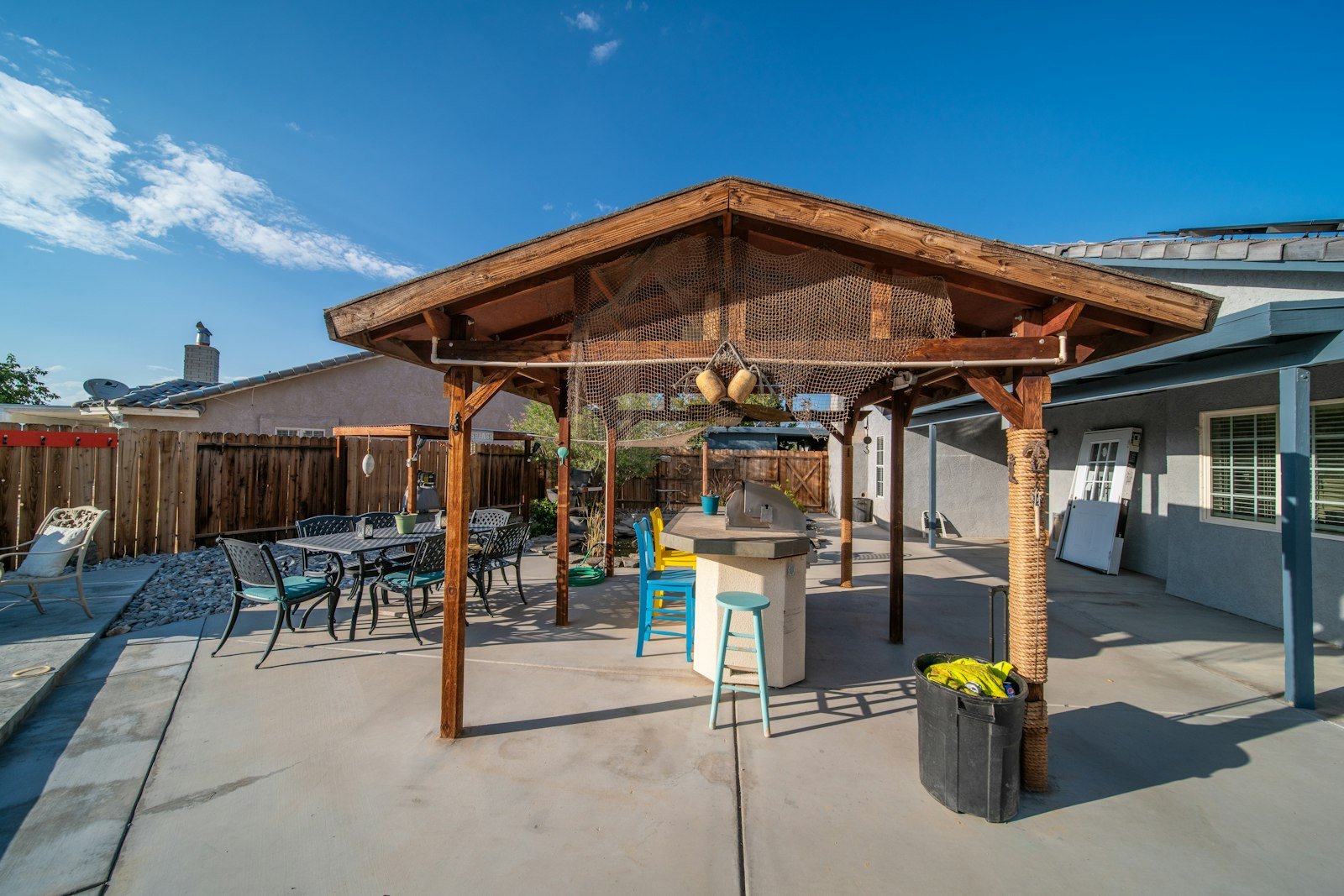 Covered outdoor living area beside a swimming pool